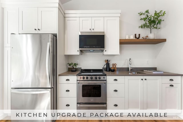 kitchen with sink, appliances with stainless steel finishes, light hardwood / wood-style flooring, and white cabinets