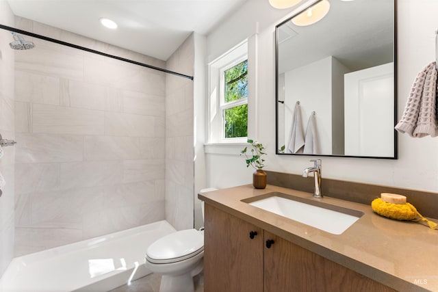 bathroom with vanity, toilet, and tiled shower