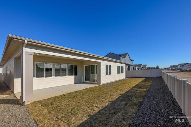 rear view of property with a patio and a lawn