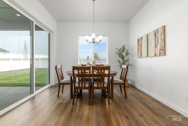 dining area with an inviting chandelier, dark hardwood / wood-style floors, and a wealth of natural light