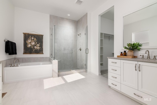 bathroom featuring vanity and independent shower and bath