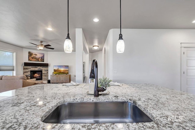 633 Reese Rd, Twin Falls, ID 83301 - kitchen featuring a ceiling fan, light stone countertops, a stone fireplace, pendant lighting, and recessed lighting
