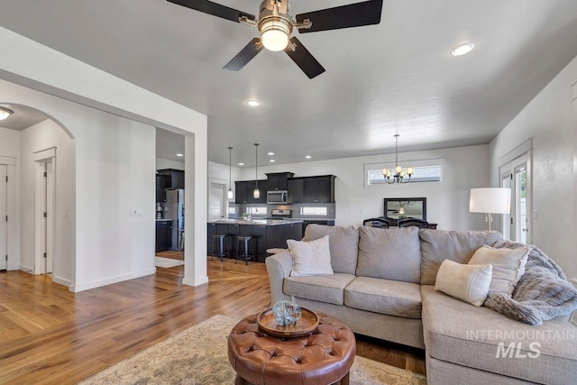 633 Reese Rd, Twin Falls, ID 83301 - living area featuring arched walkways, light wood-type flooring, a chandelier, a ceiling fan, and recessed lighting