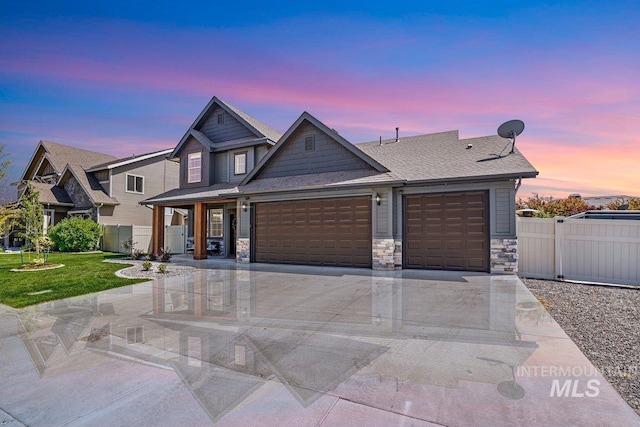 633 Reese Rd, Twin Falls, ID 83301 - view of front facade with an attached garage, stone siding, concrete driveway, and roof with shingles