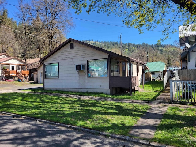 240 N D St, Orofino, ID 83544 - view of home's exterior featuring a yard, an AC wall unit, and fence