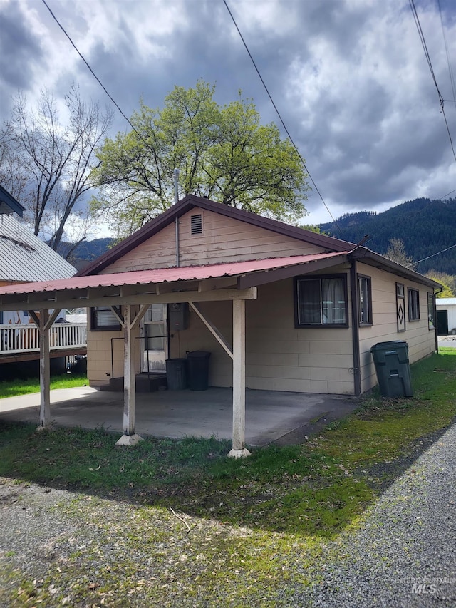 240 N D St, Orofino, ID 83544 - view of side of home featuring a carport, a mountain view, and metal roof