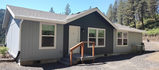 view of front facade featuring roof with shingles and crawl space