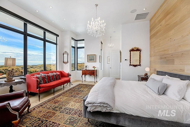 bedroom with hardwood / wood-style flooring, a notable chandelier, and wood walls