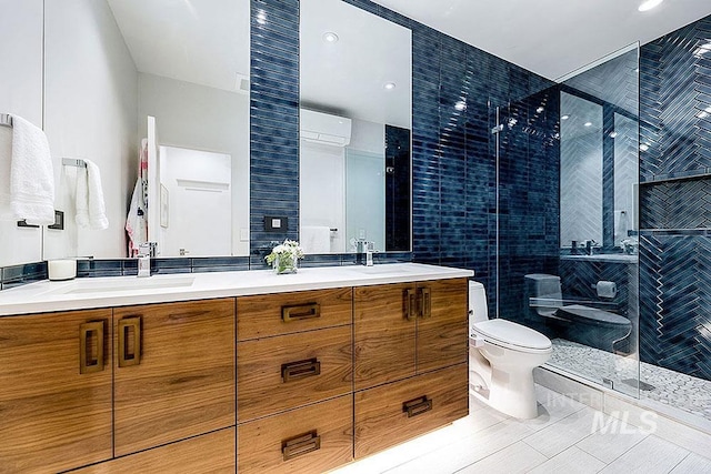 bathroom with a wall mounted air conditioner, tile patterned flooring, toilet, vanity, and a shower with shower door