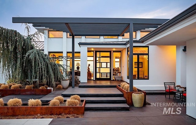 view of exterior entry with a pergola