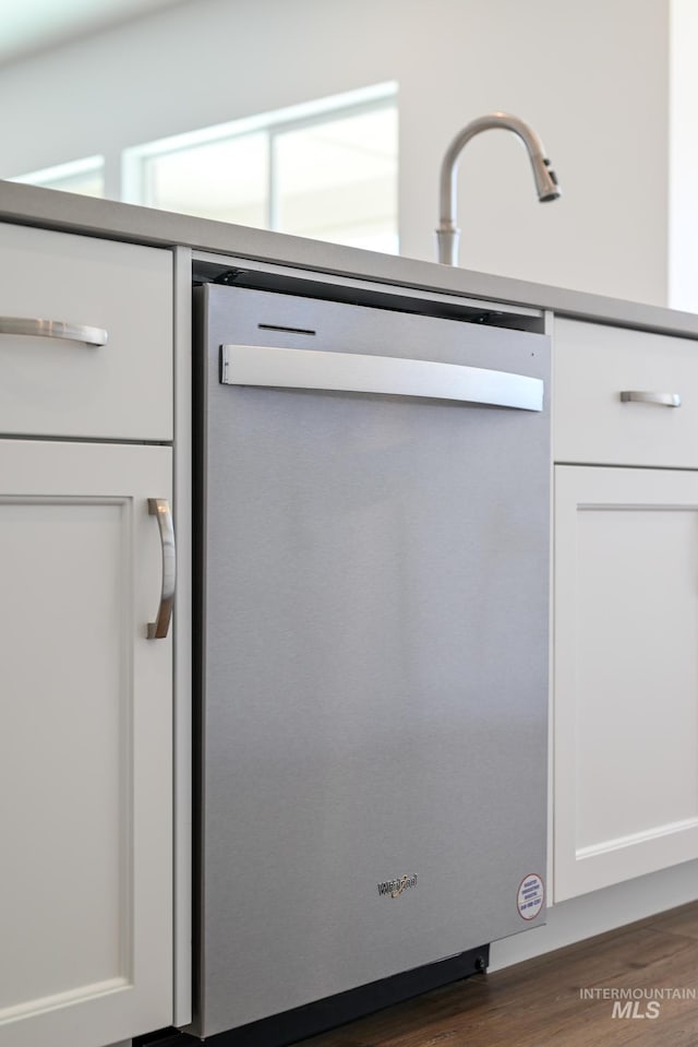 details featuring dark wood finished floors, white cabinetry, and dishwasher