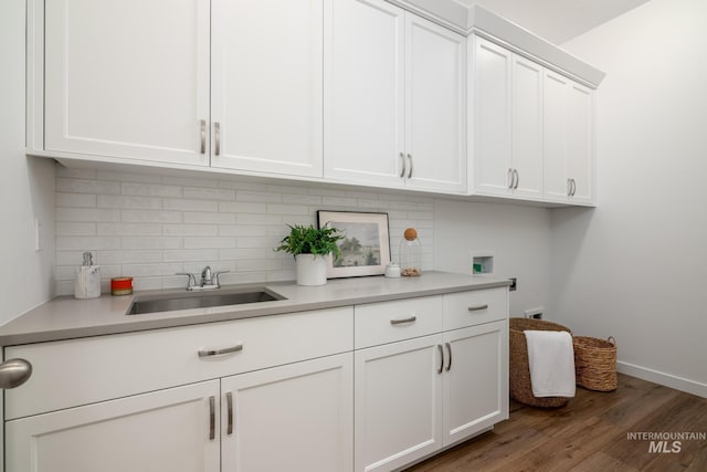 washroom with hookup for a washing machine, baseboards, a sink, cabinet space, and wood finished floors