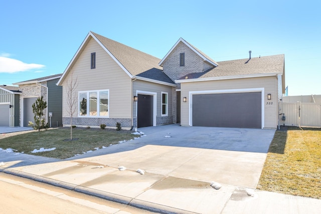 view of front of home featuring a gate, concrete driveway, fence, an attached garage, and a front lawn