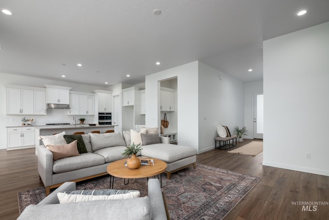 living area featuring baseboards, recessed lighting, and dark wood-style flooring