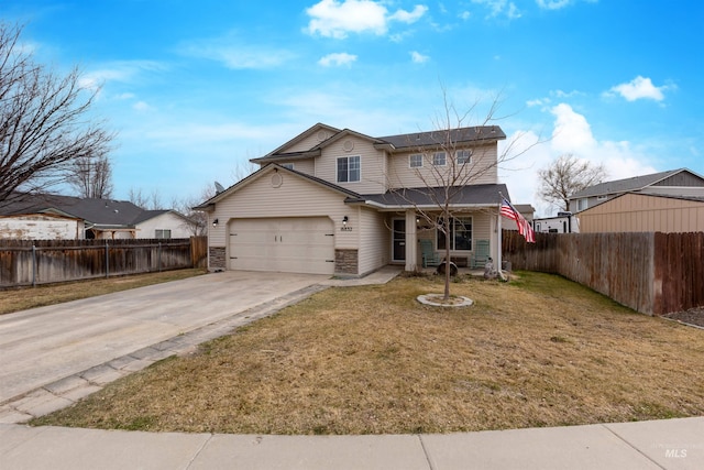 traditional-style home with driveway, an attached garage, a front yard, and fence