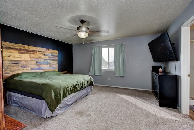 carpeted bedroom featuring a textured ceiling, baseboards, and a ceiling fan