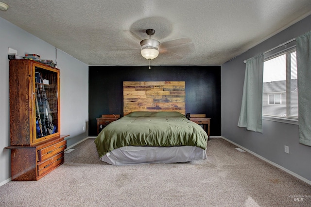 carpeted bedroom featuring a textured ceiling, baseboards, and a ceiling fan