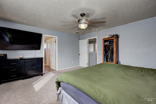 bedroom with ceiling fan, carpet flooring, visible vents, and a textured ceiling