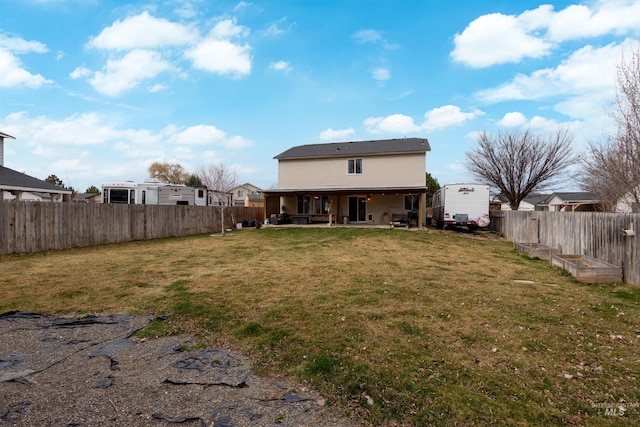 rear view of house with a garden, a patio, a lawn, and a fenced backyard