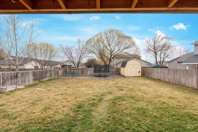 view of yard featuring a fenced backyard, an outbuilding, a trampoline, and a storage shed