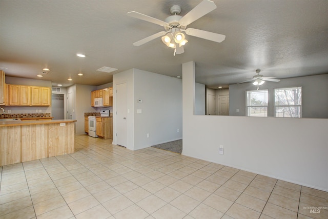 kitchen with light tile patterned flooring, sink, light brown cabinets, kitchen peninsula, and white appliances