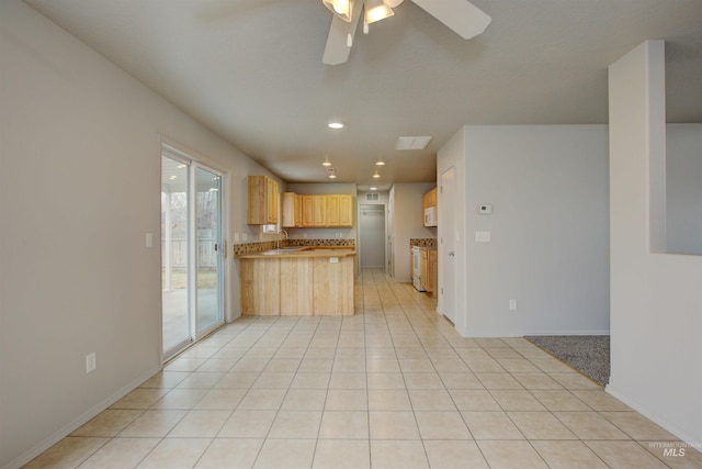 kitchen featuring sink, light tile patterned floors, light brown cabinets, kitchen peninsula, and white appliances