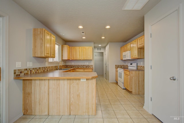 kitchen with light tile patterned flooring, light brown cabinetry, sink, kitchen peninsula, and white appliances