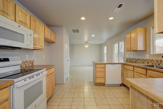 kitchen featuring sink, white appliances, light tile patterned floors, light brown cabinets, and ceiling fan