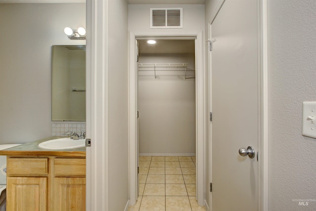 bathroom with tile patterned floors, toilet, vanity, and backsplash