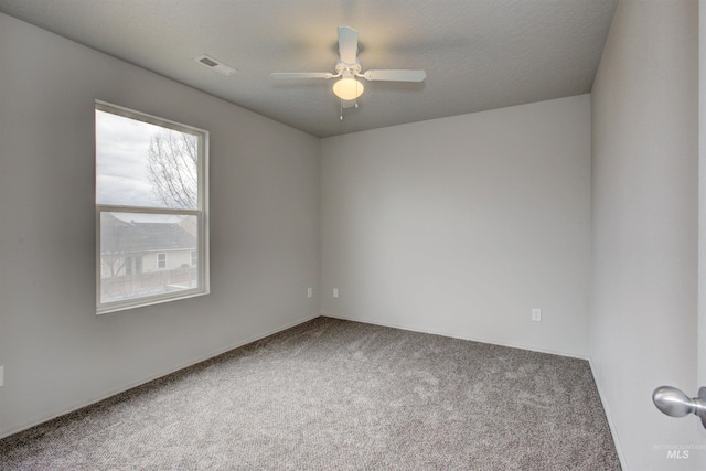 carpeted spare room with a textured ceiling and ceiling fan