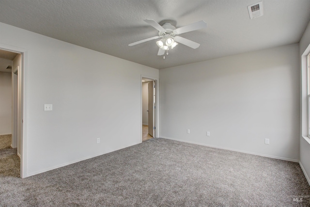 spare room with ceiling fan, light carpet, and a textured ceiling