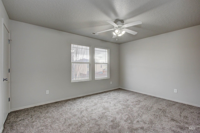 carpeted spare room featuring a textured ceiling and ceiling fan