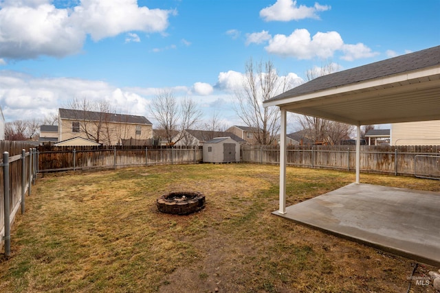 view of yard featuring a storage unit, a patio, and a fire pit