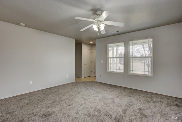 carpeted empty room with ceiling fan and a textured ceiling