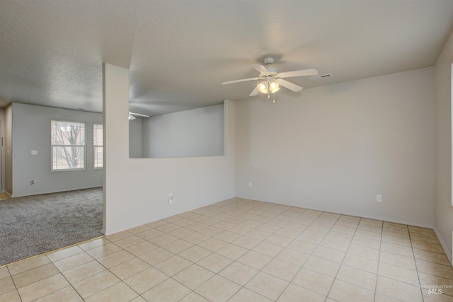 tiled empty room featuring ceiling fan and a textured ceiling