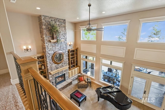 7406 Wild Horse Way, Nampa, ID 83686 - living area featuring an inviting chandelier, a textured ceiling, a stone fireplace, french doors, and baseboards