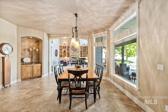 7406 Wild Horse Way, Nampa, ID 83686 - dining room with a textured ceiling, baseboards, and arched walkways