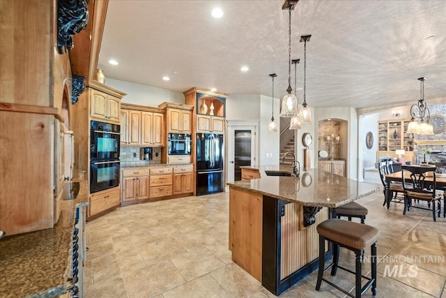 7406 Wild Horse Way, Nampa, ID 83686 - kitchen featuring arched walkways, tasteful backsplash, black appliances, stone counters, and a breakfast bar