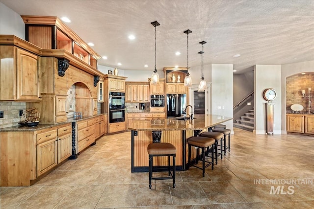 7406 Wild Horse Way, Nampa, ID 83686 - kitchen with a spacious island, a sink, black appliances, and tasteful backsplash