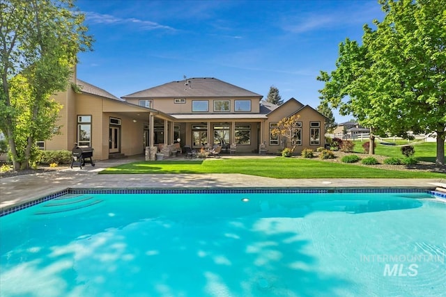 7406 Wild Horse Way, Nampa, ID 83686 - rear view of property featuring a lawn, a patio area, and an outdoor pool