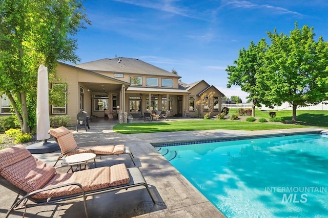 7406 Wild Horse Way, Nampa, ID 83686 - back of property featuring a lawn, a patio, and an outdoor pool