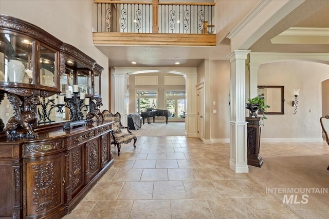 7406 Wild Horse Way, Nampa, ID 83686 - entrance foyer with decorative columns, light carpet, baseboards, a high ceiling, and arched walkways