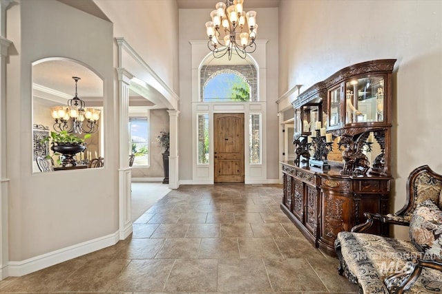 7406 Wild Horse Way, Nampa, ID 83686 - foyer featuring an inviting chandelier, stone tile flooring, baseboards, a high ceiling, and arched walkways