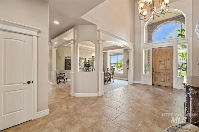 7406 Wild Horse Way, Nampa, ID 83686 - entrance foyer with ornate columns, arched walkways, baseboards, and a notable chandelier