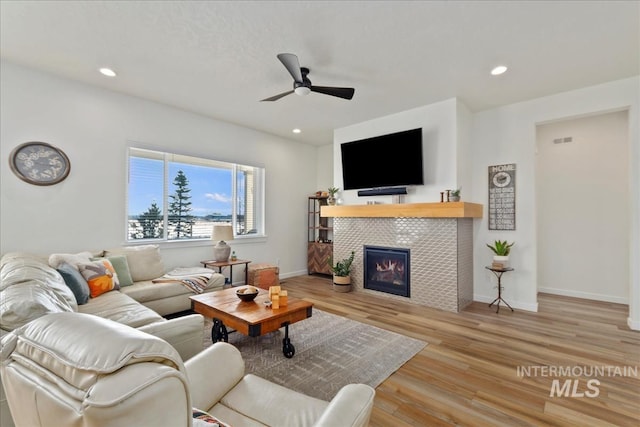 living area featuring recessed lighting, wood finished floors, a fireplace, and ceiling fan