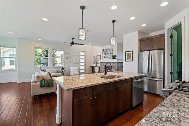 3671 S Pheasant Tail Way, Boise, ID 83716 - kitchen with appliances with stainless steel finishes, a sink, a brick fireplace, open floor plan, and a kitchen island with sink