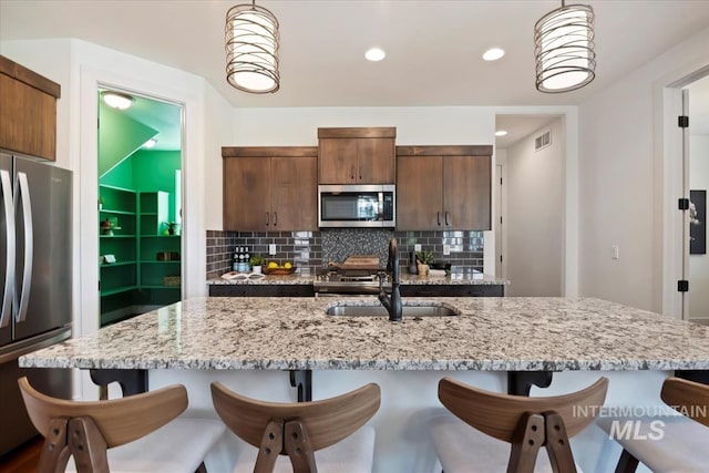 3671 S Pheasant Tail Way, Boise, ID 83716 - kitchen featuring appliances with stainless steel finishes, a sink, a breakfast bar area, hanging light fixtures, and recessed lighting