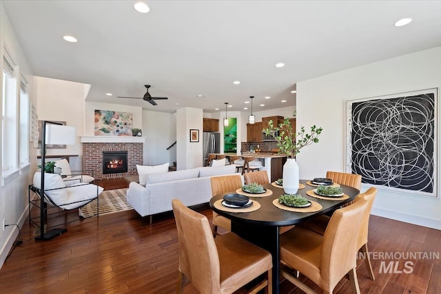 3671 S Pheasant Tail Way, Boise, ID 83716 - dining space featuring recessed lighting, dark wood-style flooring, ceiling fan, a brick fireplace, and baseboards