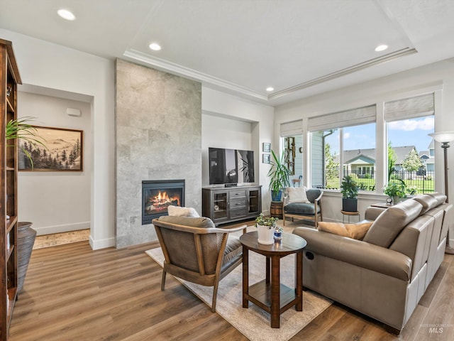 10366 Loneleaf Dr, Nampa, ID 83687 - living area featuring a tile fireplace, wood finished floors, baseboards, a tray ceiling, and recessed lighting