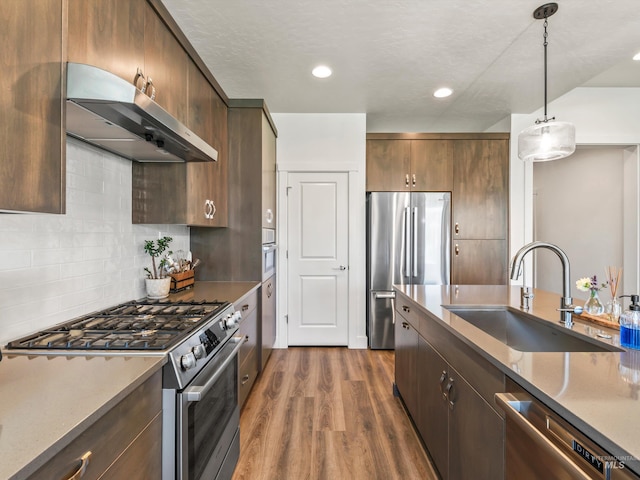 10366 Loneleaf Dr, Nampa, ID 83687 - kitchen with stainless steel appliances, extractor fan, a sink, dark wood-type flooring, and hanging light fixtures